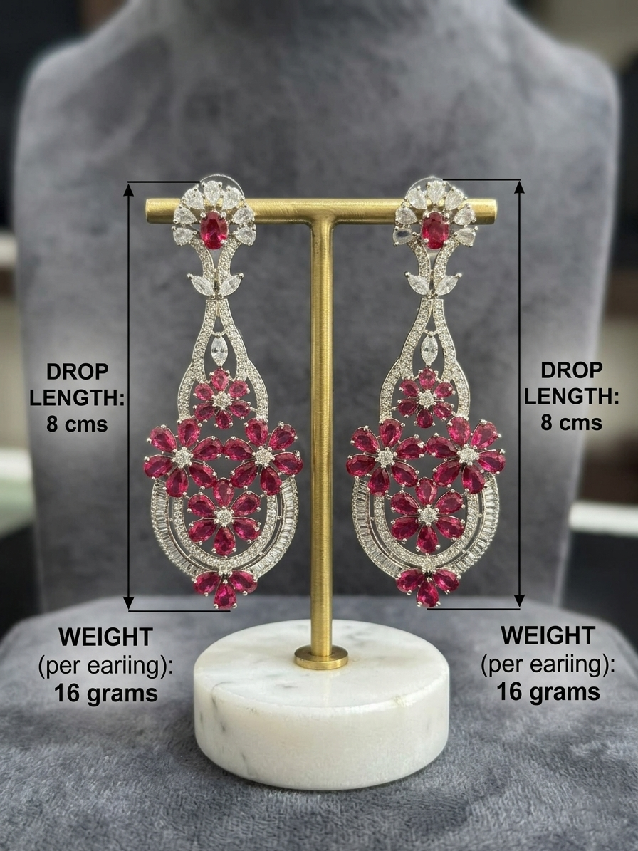 Long ruby and crystal floral statement earrings on a display stand with 8 cm drop length and 16-gram weight annotations.