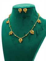 The Minakari green stone necklace displayed on professional jewellery stands.