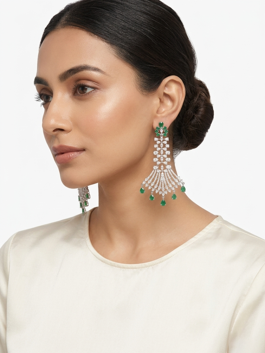 Long American Diamond and green emerald-style statement chandelier earrings .