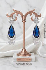 Traditional 5 cm wide American Diamond Chaand Bali earrings with radiant ruby-red accents on a clean background.