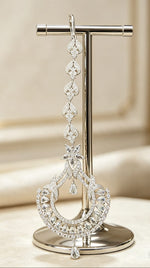 The Siya Extended Star & Crescent Luxe Cubic Zirconia Maang Tikka — silver-toned, cascading floral-teardrop links, star motif, pear & round cut CZ stones, long bridal forehead jewelry, Indian Pakistani wedding ornament displayed on stand.