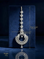 The Siya Signature Long-Line Luxe Cubic Zirconia Maang Tikka — silver-toned, cascading petal links, star & crescent design with pear-cut drops, drop length 12.5 cm, width 3.5 cm, weight 15 g, premium bridal forehead jewelry displayed on navy velvet.