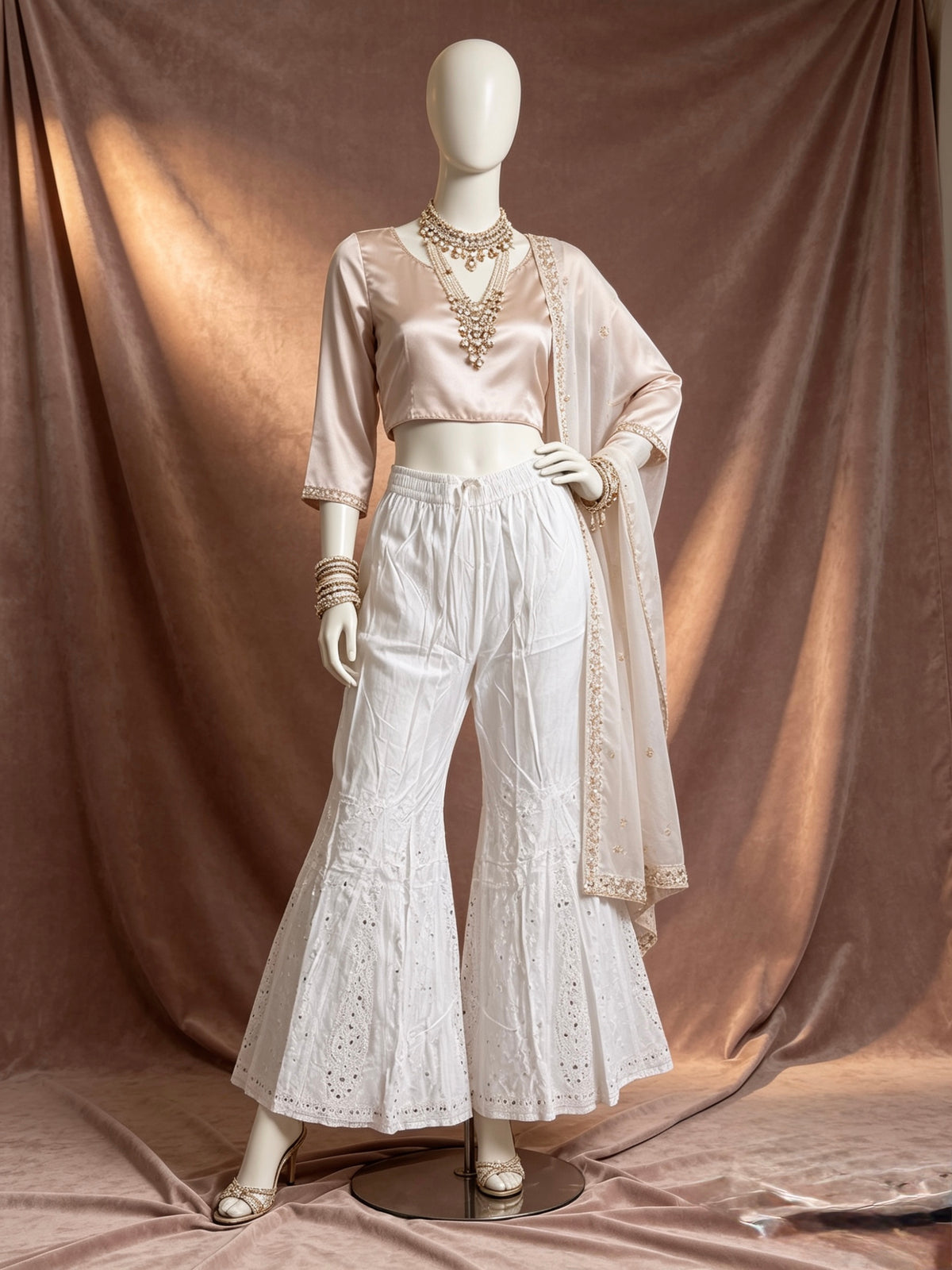 The White cotton sharara with hand bakhiya embroidery and silver kaamdani work.
