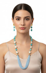 A black mannequin showcasing a Bollywood style sky blue colour Mona Lisa stone and blue colour nano crystal beaded Mala set, with white colours of baroque pearls and gold-tone accents.