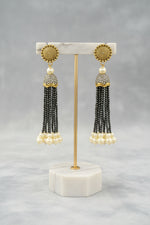 The gold-plated Kundan-studded and pearl-beaded handcrafted earrings, displayed against a black background. Party wear earrings set.