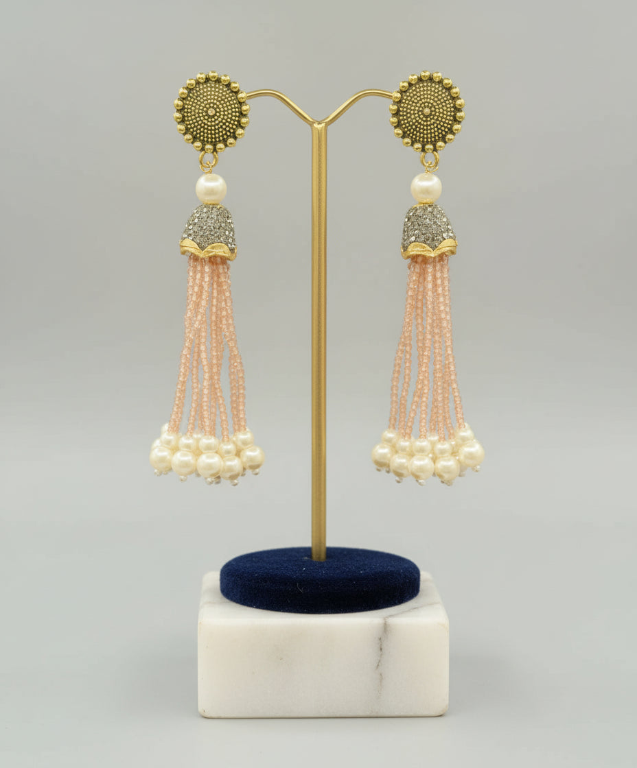 The gold-plated Kundan-studded and pearl-beaded handcrafted earrings, displayed against a black background. Party wear set.