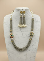 The luxurious Tanjore Art Meenakari grey beaded Mala Set featuring a bridal pearl necklace with accompanying earrings, predominantly in gold and white colours with ornate designs.