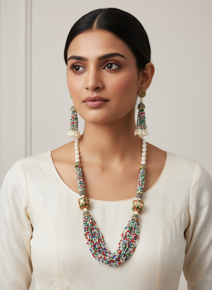 The luxurious Tanjore Art Meenakari multi-coloured beaded Mala Set featuring a bridal pearl necklace with accompanying earrings, predominantly in gold and white colours with ornate designs.