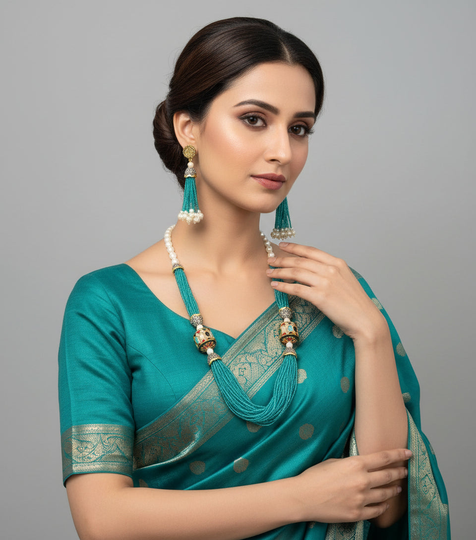 The luxurious Tanjore Art Meenakari turquoise beaded Mala Set featuring a bridal pearl necklace with accompanying earrings, predominantly in gold and white colours with ornate designs. Party wear set.