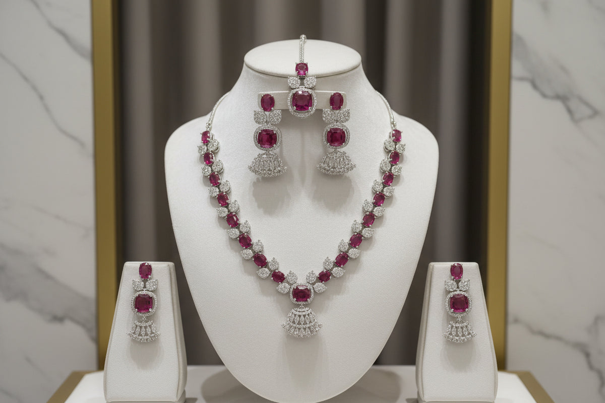 The mannequin showcasing a necklace set with ruby pink and white ad stones, accompanied by earrings and a maang tikka. Party wear set.
