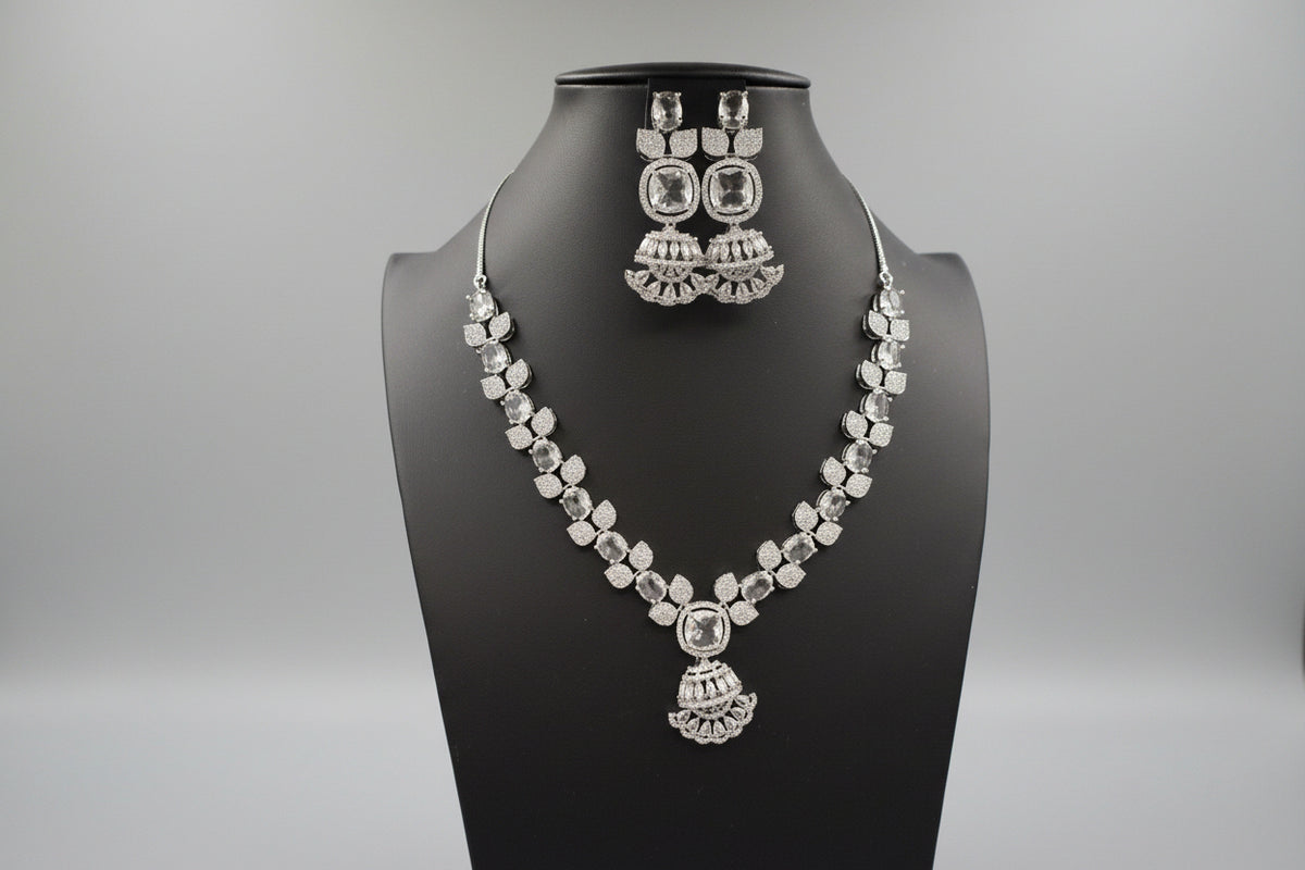 A mannequin showcasing a silver plated necklace set with pink and white stones, accompanied by earrings and a maang tikka. Party wear ad set.