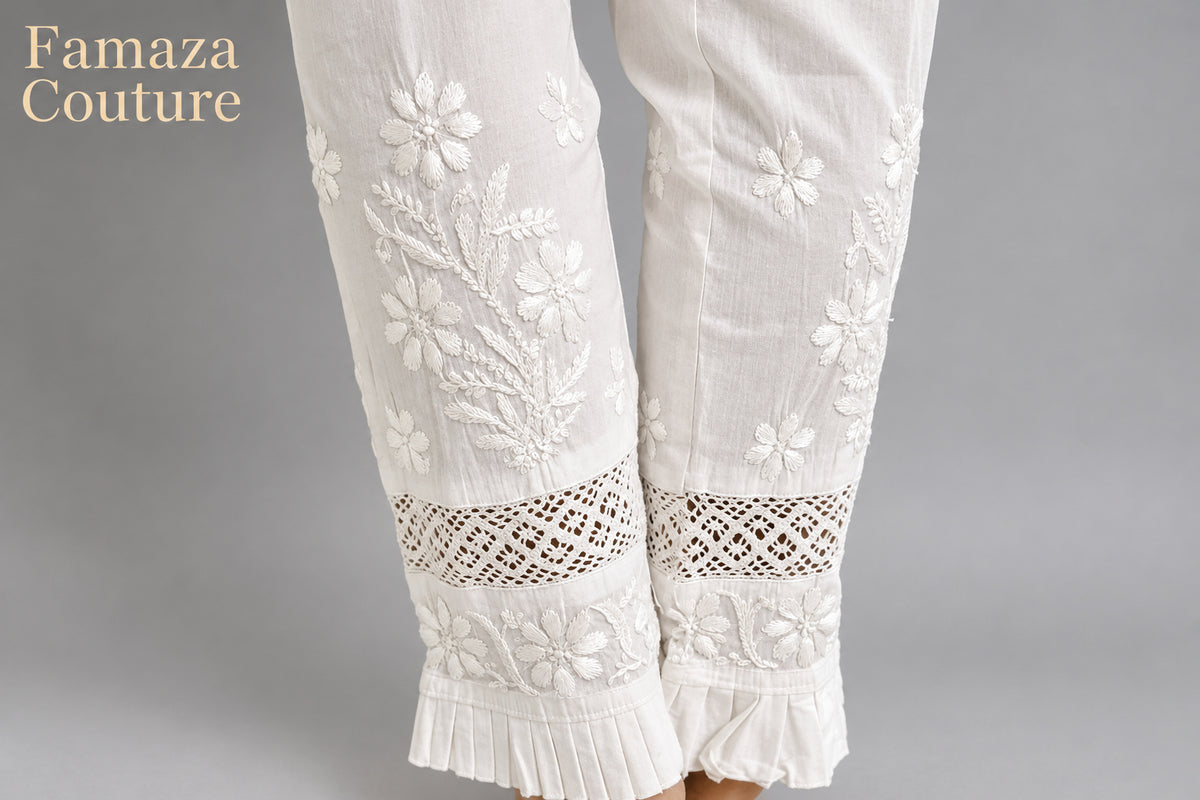 The rear view close-up of white embroidered cotton pants with pockets, showing the texture and design details.