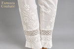 The rear view close-up of white embroidered cotton pants with pockets, showing the texture and design details.