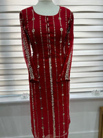 Therose red party wear dress with zari embroidery and pearl embellishments displayed on a mannequin.