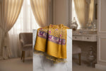 The yellow pashmina scarf with Kashmiri embroidery in a floral pattern, featuring tassels on the ends.