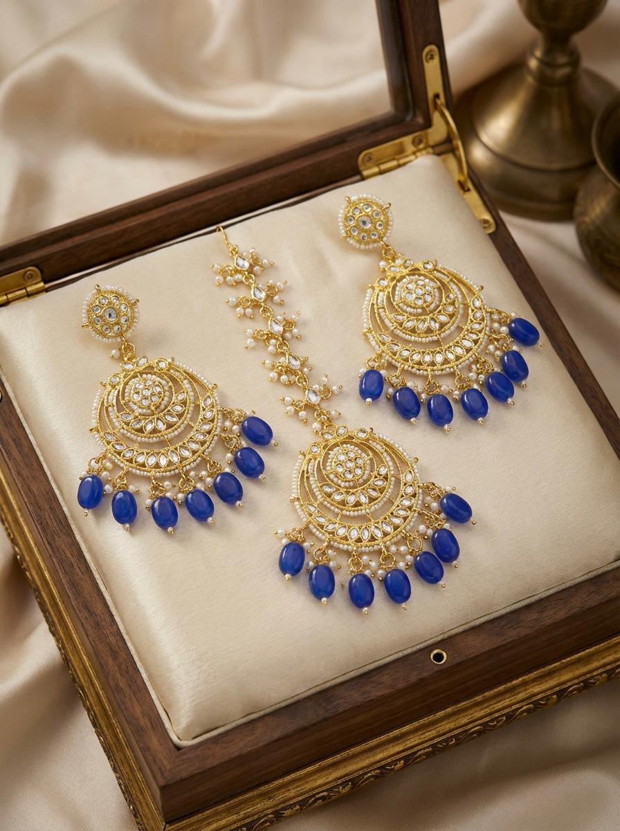 Traditional Indian Maang Tikka and jhumka earring with a sapphire-toned bead fringe and intricate kundan center.