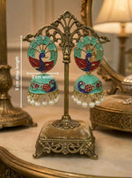Turquoise blue 5.5cm Meenakari peacock jhumkas on a display card highlighting the detailed bird stud.