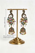 Product display view of Vintage Peacock Glow antique gold-plated multistone jhumka earrings hanging on a gold stand, showcasing drop length and weight specifications.