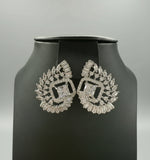 White centre AD stone earrings, featuring a geometric design with intricate detailing, displayed on a black mannequin. Party wear set.