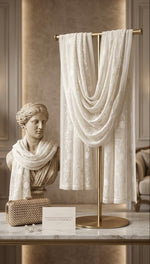 White chiffon dupatta with Kashmiri aari jaal embroidery all over the dupatta draped over a mannequin, statue, and handbag on a marble surface with a classical sculpture in the background.