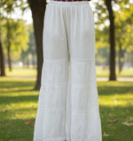 White embroidered pants on a mannequin in a clothing store.