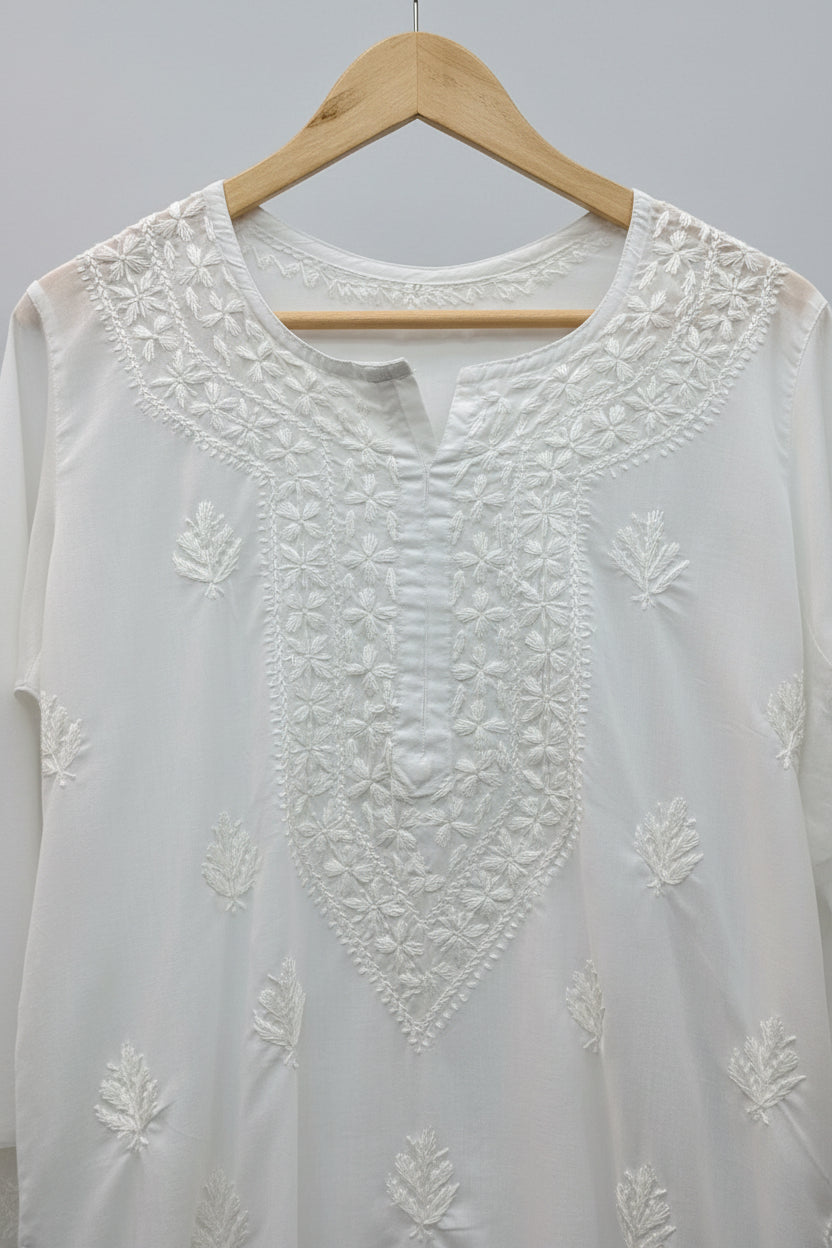 White embroidered kurti is shown and the neckline embroidery is focused for the customer to understand the embroidery on the neckline.