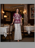 White embroidered pants on a mannequin in a clothing store.