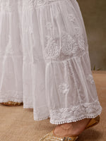 White embroidered skirt with floral patterns on a neutral background
