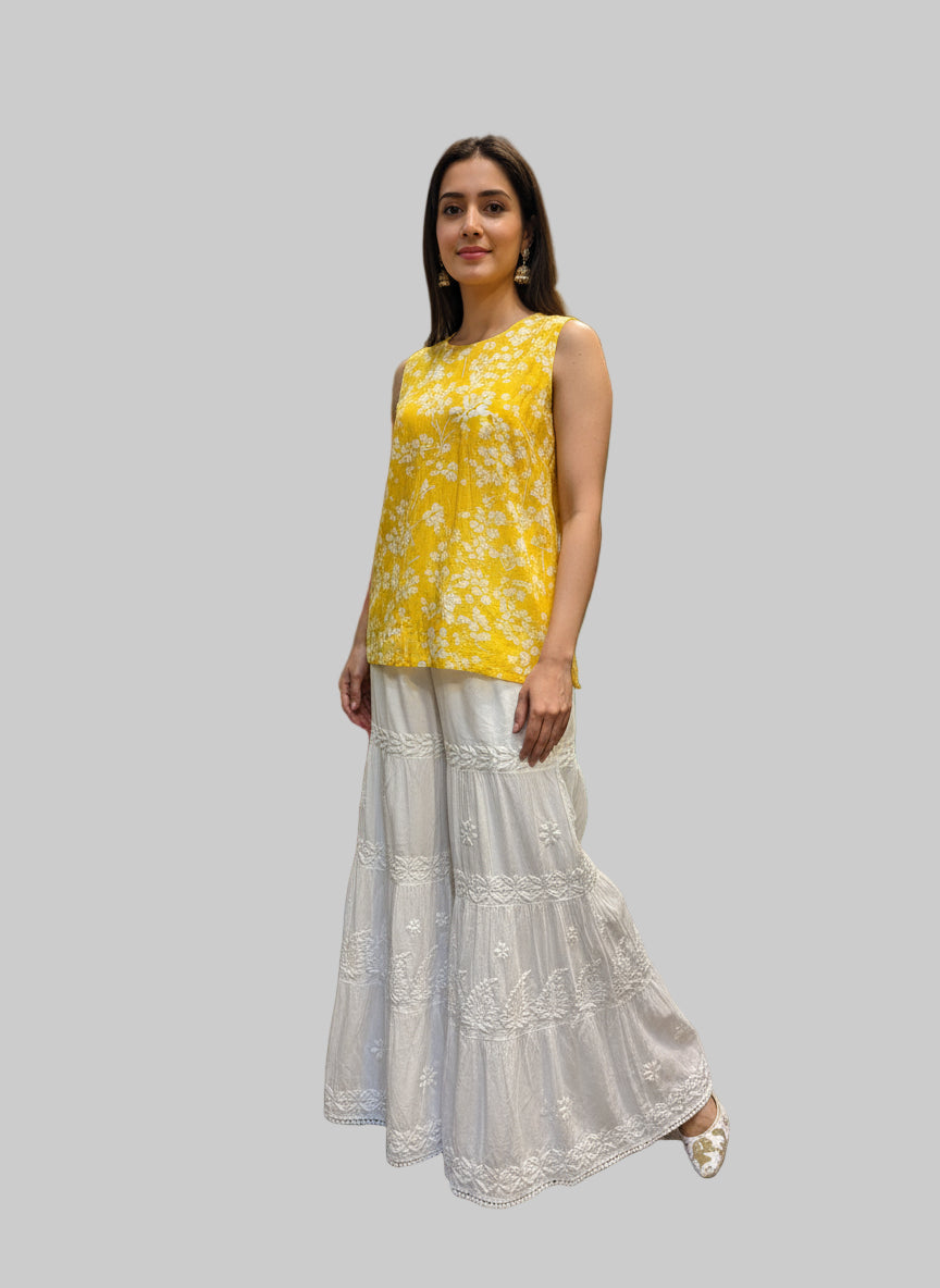 White lace flared trousers on a mannequin with colourful fabric in the background