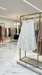 White lace dress on a rack with other clothing items in the background