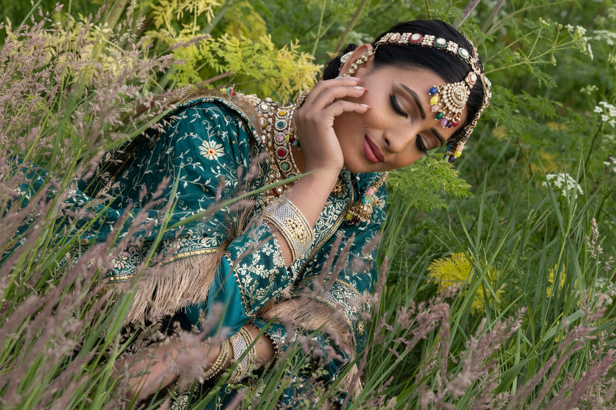 Woman in traditional attire among flowers and greenery
