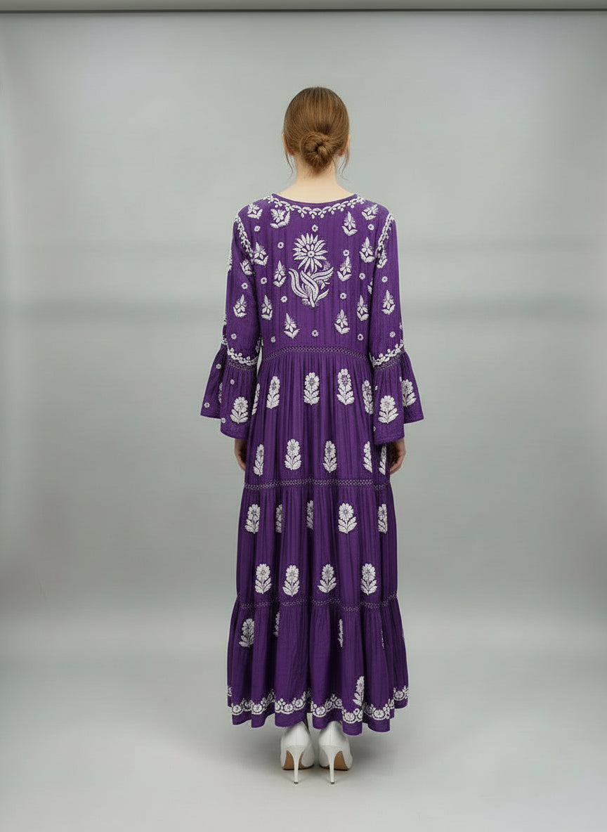 Woman is showing rear view of thispurple dress with white floral patterns in a neutral setting.