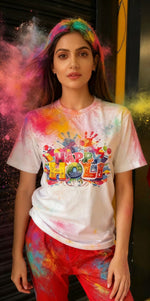 Woman wearing a 'Happy Holi' t-shirt with colorful powder around her.