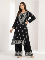 Woman wearing a black base rayon fabric 45 inches long kurti and 38 inches long trousers with white hand embroidered outfit on a white back