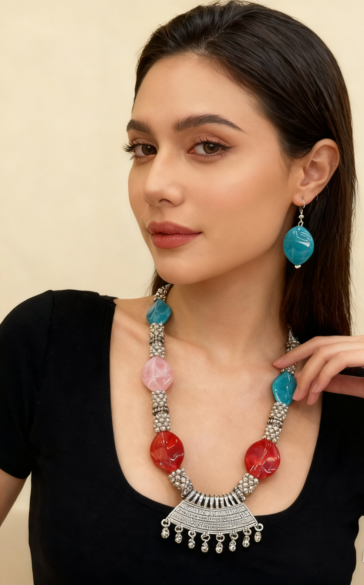 Woman wearing a colourful beaded necklace and earrings on a beige background