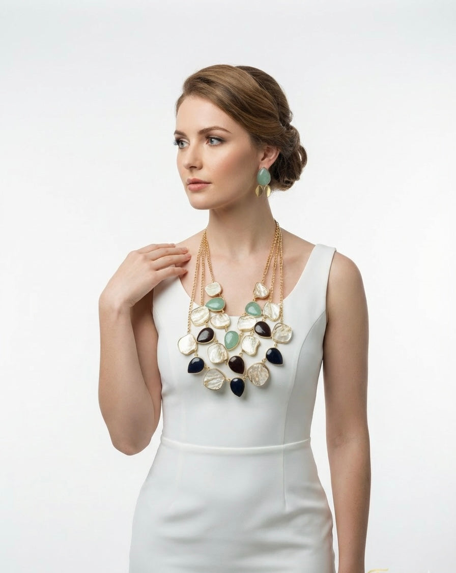 Woman wearing a long, multi-layered necklace with various colored stones on a white background