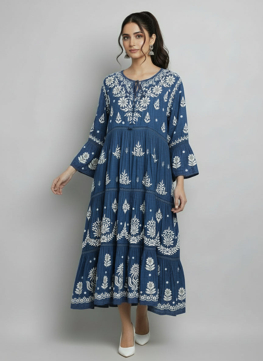 Woman wearing a navy blue colour dress with white floral patterns in a neutral setting.