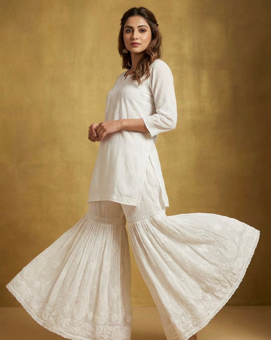 Woman wearing a whitetop and white flared hand embroidered gharara pants