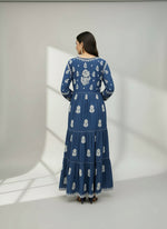 Woman wearing and showing rear view design of this navy blue colour dress with white floral patterns in a neutral setting.