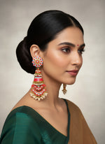 Woman wearing elaborate earrings with a neutral background