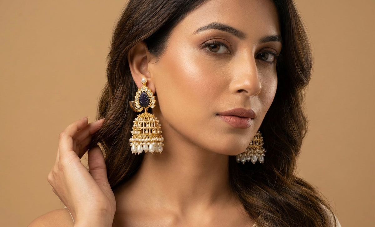 Woman wearing gold earrings with a beige background