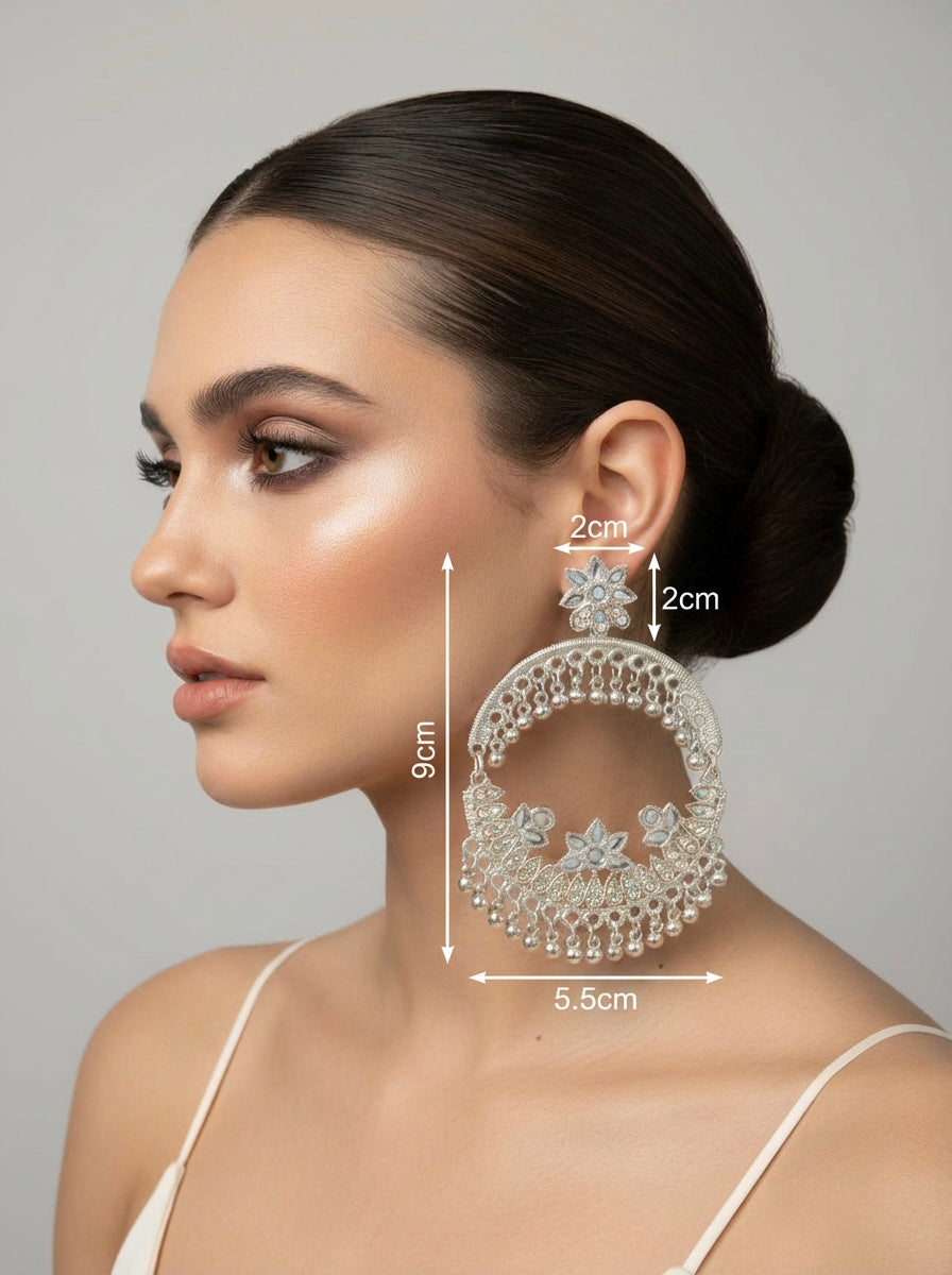 Woman wearing large decorative earrings with measurements indicated