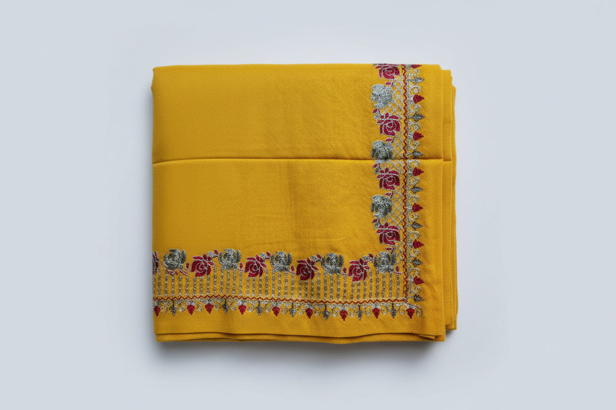 Yellow fabric with floral embroidery on a white background