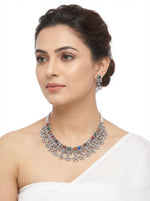Young woman wearing the Iris artisanal multicolour silver oxidised choker and earrings with green accents, styled for an elite evening jewellery look.
