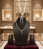 a rhodium-plated jewellery set with American diamond and semi-precious stones, including a necklace, earrings and maang tikka by famaza couture