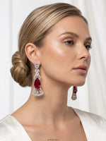 Model wearing Aurora Jem silver geometric statement earrings with large pear-cut red ruby drop stone and marquise diamond accents.