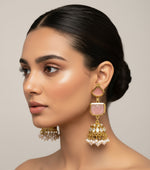 A pair of gold-plated sugar stone drop jhumka earrings with pink stones and white pearl-like accents.
