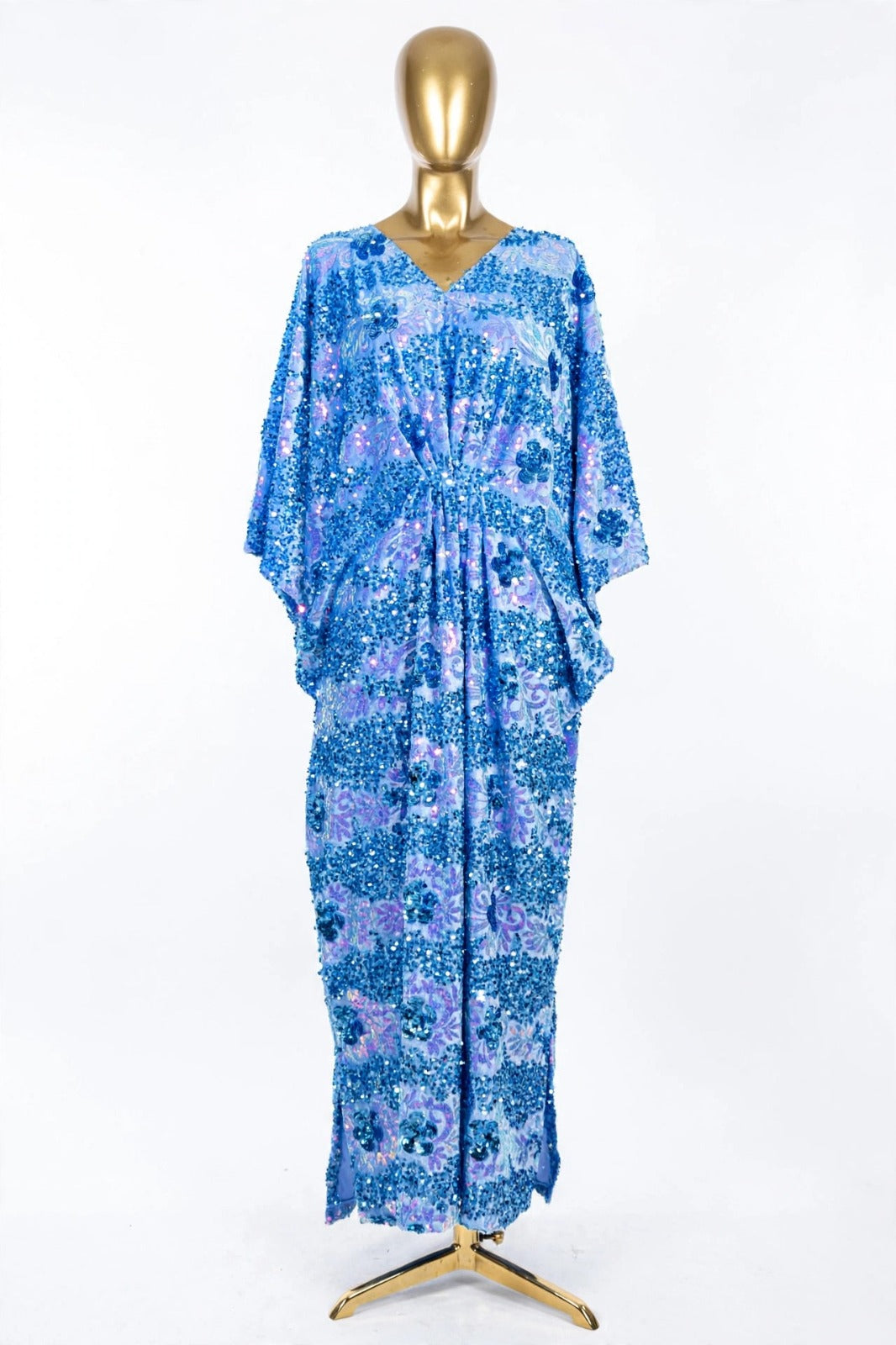 Blue Radiance floral sequin velvet kaftan on a gold mannequin, showing its long batwing sleeves and flowing silhouette