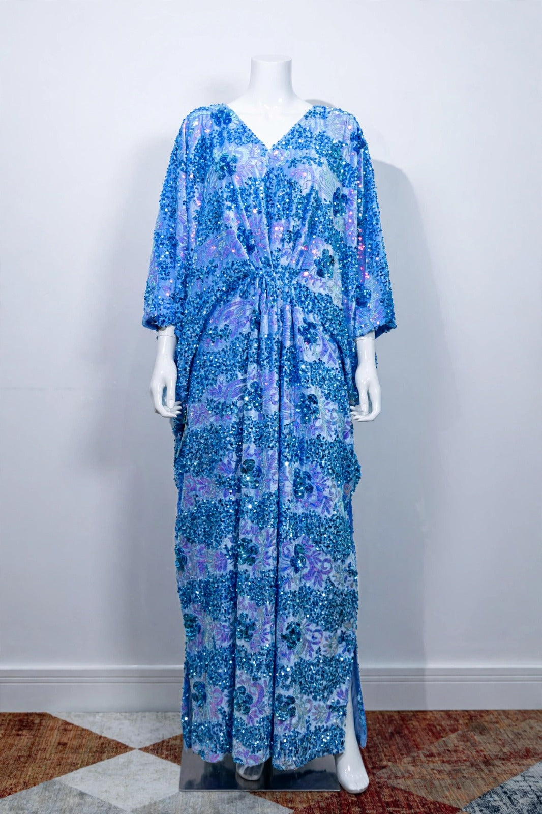 Front view of the Blue Radiance blue velvet kaftan on a white mannequin, showing its V-neck and gathered waist