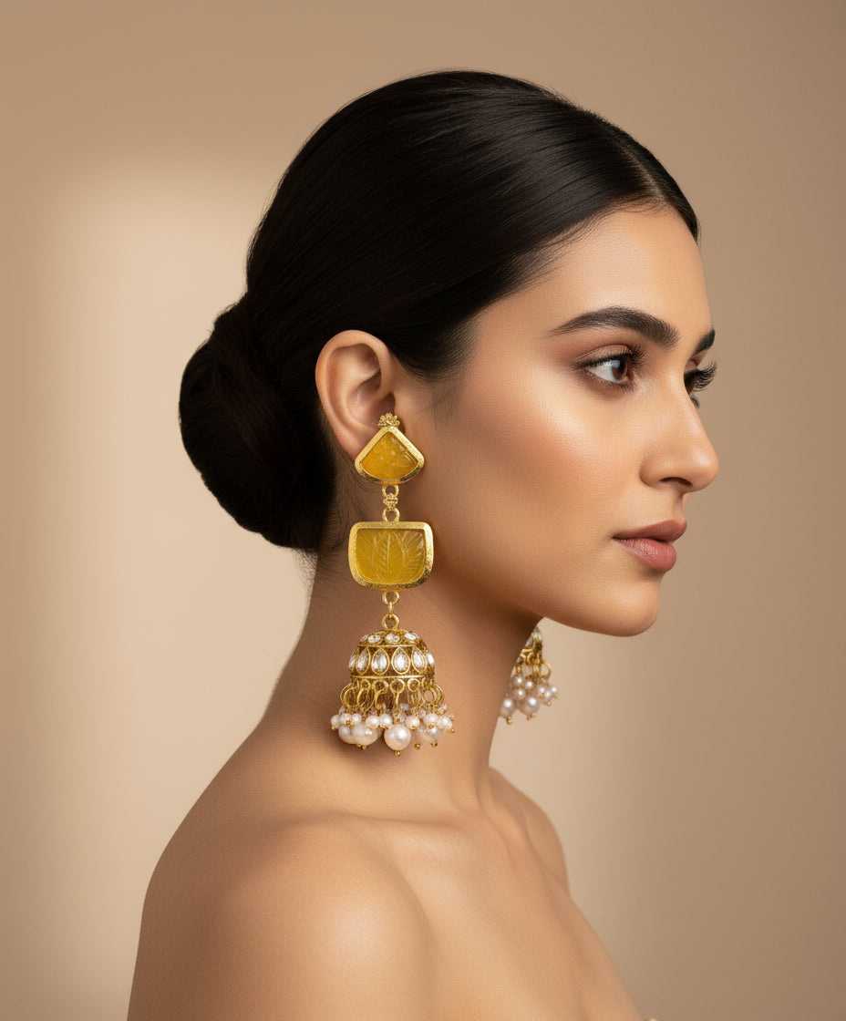 A pair of gold-plated sugar stone drop jhumka earrings with pink stones and white pearl-like accents.